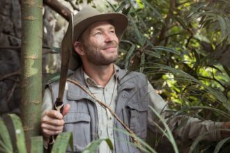 man in gray button up shirt holding green bamboo stick