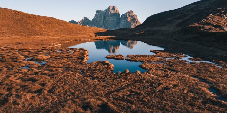 A mountain range with a lake in the foreground
